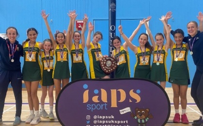 9 girls and their coaches Sophie Meister and Caitlin Rump hold the shield after winning U12 IAPS
