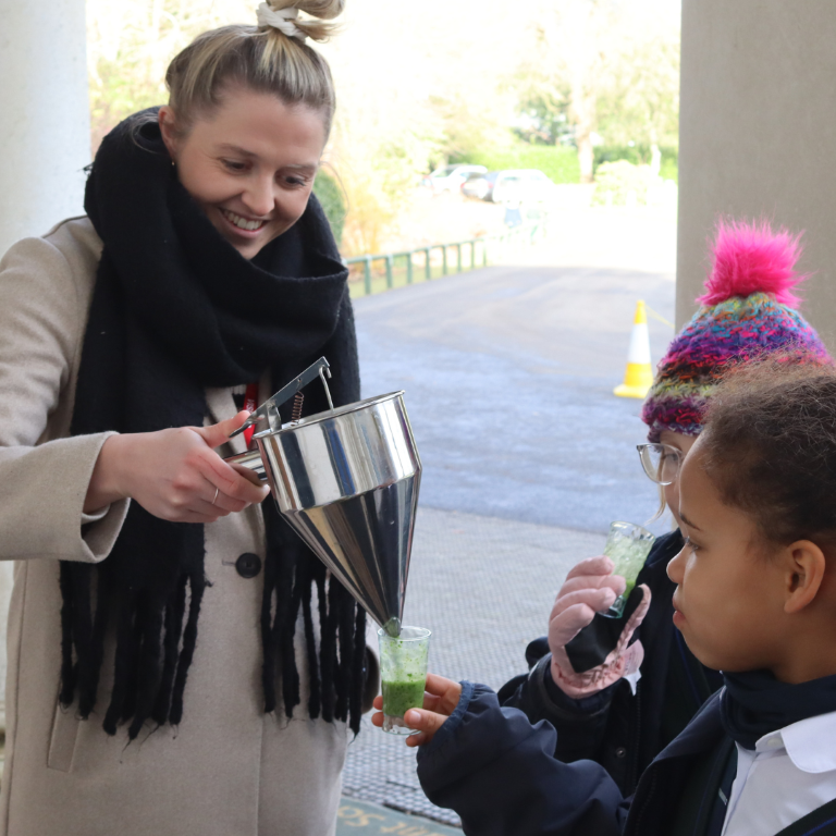 Nutritionist pours healthy smoothies for pupils during Nutrition Day