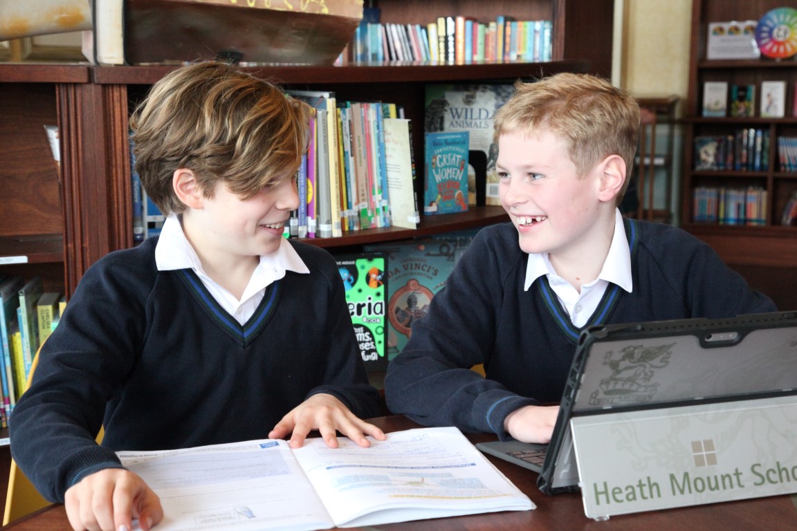 Year 7 pupils work in the library on their laptop devices