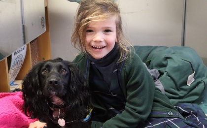 Girl hugs new nurture dog Luna who helps with pastoral care and wellbeing at Heath Mount