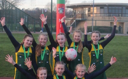 U13 netball team pose with gold medals at Millfield School netball tournament