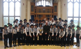 Members of Bax Consort choir pose with composer Bob Chilcott and their trophy after winning the choir competition