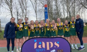 Heath Mount's U13 netballers stand with their gold medals alongside their coaches at Millfield School