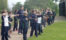 a group of Heath Mount children try their hand at archery at Cressing Temple Barns in Essex